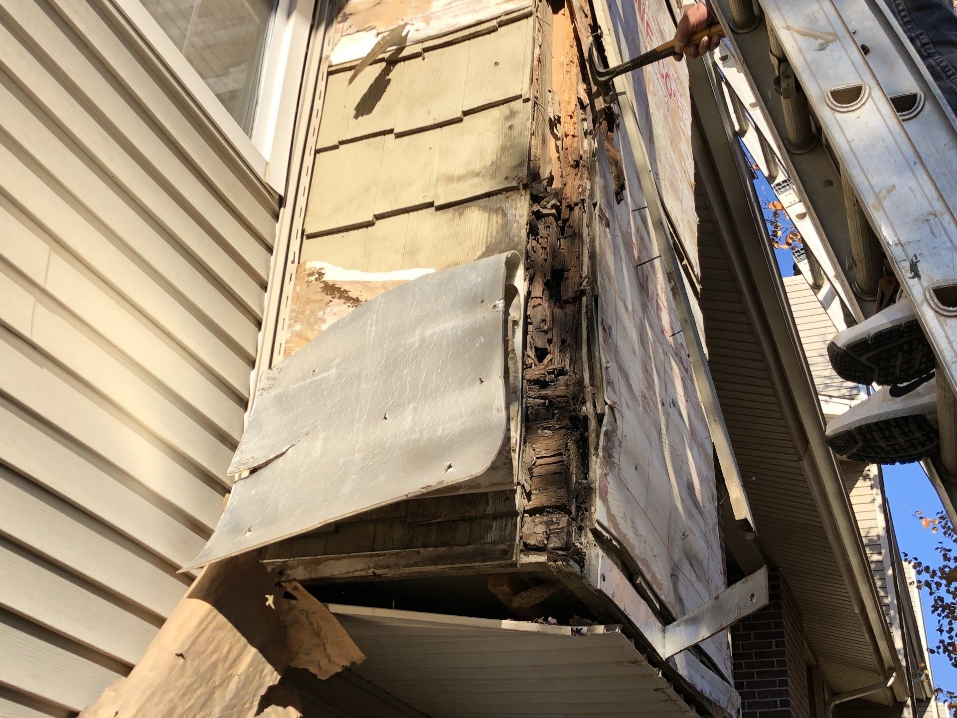 P.I. Roofing inspects a damaged siding for repair or replacement