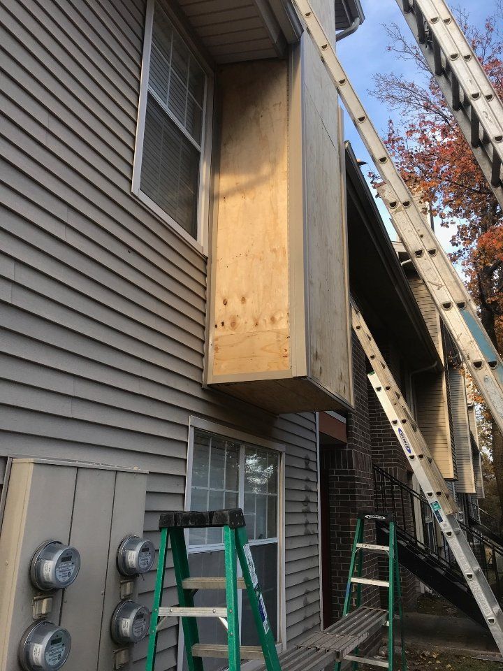 P.I. Roofing shows safety practices when fixing a wood siding